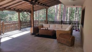 潘尼希特Hunting Residence Lodge的一个带沙发和藤椅的屏蔽门廊