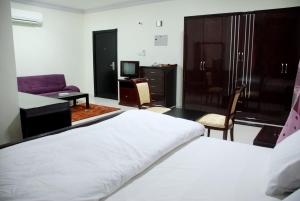 阿吉曼Paradise Inn Hotel (Tabasum Group)的一间卧室配有一张床、一张沙发和一台电视。