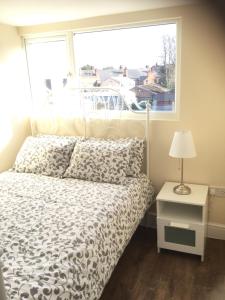 伯明翰Modern Chic Loft Apartment的一间卧室配有一张带窗户的床