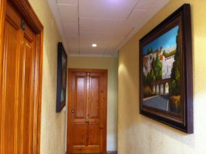 阿尔卡拉德瓜代拉桑德拉酒店的走廊上设有门,墙上挂着一幅画