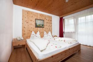 安泰塞尔瓦·迪·梅佐梅斯内维特酒店的一间卧室配有一张大床和木制床头板