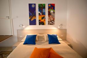 莫斯塔Apartment 81的一间卧室配有蓝色和橙色枕头的床