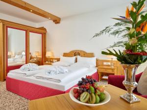 巴特格里斯巴赫Hotel Maximilian的酒店客房,配有一张床和一碗水果放在桌子上