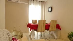 加的斯Cosy Caleta Apartment的一间用餐室,配有红色的桌子和椅子