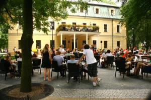 RybnaPalac w Rybnej的一群坐在大楼前桌旁的人
