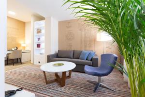 贝尔格莱德Hotel TESLA - Smart Stay Garni的客厅配有沙发、桌子和椅子