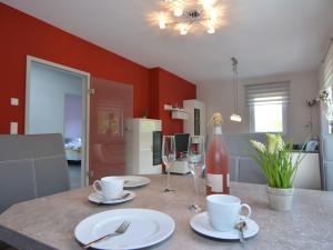 塔巴尔茨Modern apartment Thuringia的厨房配有带盘子和酒杯的桌子