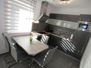 塔巴尔茨Modern apartment Thuringia的厨房配有桌子、水槽和冰箱