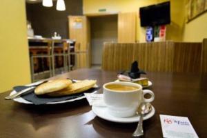 阿尔赫西拉斯马日亚路易撒酒店的坐在桌子上,一边喝咖啡一边用勺子