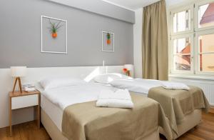 布拉格花苑酒店的一间卧室设有两张床和窗户。
