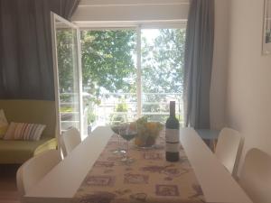 茨里克韦尼察Holiday home LoLa的餐桌、一瓶葡萄酒和窗户