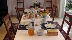Coeuve蓝色小屋住宿加早餐旅馆的餐桌上摆放着水果和果汁