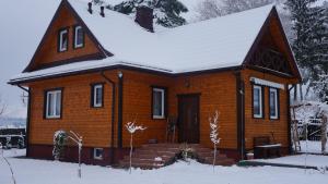 KopiskUroczysko Ostoja的屋顶上积雪的小木屋