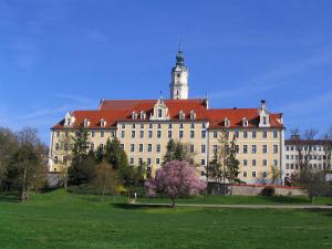 Asbach-Bäumenheim多瑙河之星公寓式酒店的一座大型建筑,上面有一个钟楼