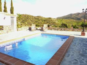 比纽埃拉Belvilla by OYO Casa El Cerro的山前的蓝色海水大型游泳池
