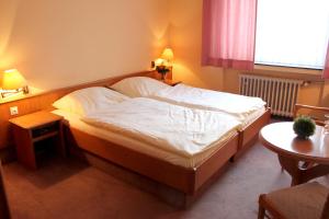 巴特布雷希格尼德瑞酒店的一间卧室配有一张带白色床单的大床