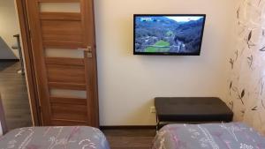 奥泰佩Tehvandi Ski Apartment的一间墙上配有电视的房间和一张床