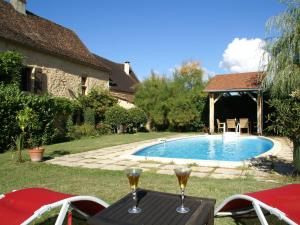 NanthiatModern holiday home in Aquitaine with pool的一个带两杯酒的游泳池
