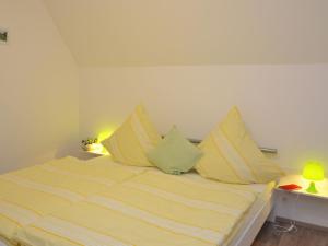 施马伦贝格Charming holiday home near the ski area的一张带黄色和白色条纹床单和枕头的床