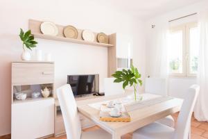 托雷桑塔萨宾娜Appartamento Panorama的白色的用餐室配有桌椅