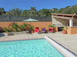莱德农Modern Villa with Private Swimming Pool in L denon的一个带两把椅子和遮阳伞的游泳池