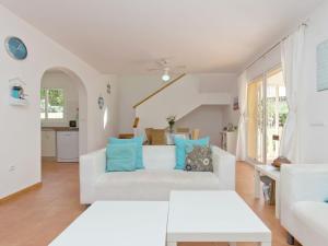 库姆布勒德尔索尔Belvilla by OYO Villa Junique的客厅配有白色沙发和蓝色枕头。