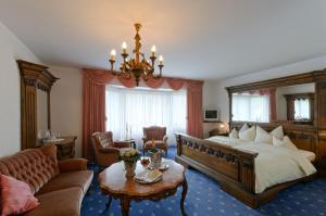 朗根费尔德兰德罗曼酒店的一间卧室配有一张大床和一个吊灯。