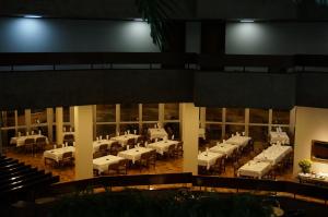 伊通比亚拉Hotel Beira Rio的大楼内带白色桌椅的用餐室