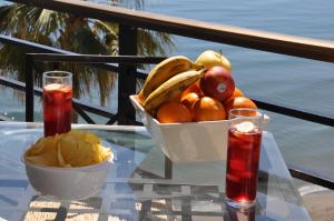 多列毛利诺斯Studio Sea View Terrace的坐在玻璃桌旁的水果碗,装有饮料
