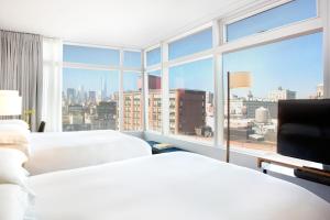 纽约东乡村设计酒店的配有大窗户的酒店客房内的两张床