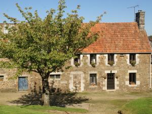 Montaigu-les-BoisCharming holiday home in a green setting的一座古老的石头房子,前面有一棵树