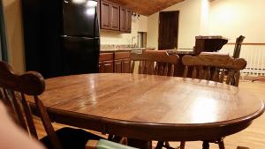 OntarioHansen House的厨房配有木桌和黑冰箱。