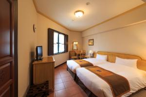 长崎长崎蒙特利酒店的酒店客房设有两张床和电视。