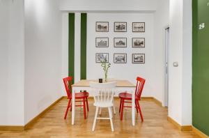 罗马圣科思玛托公寓的一间设有白色桌子和红色椅子的用餐室