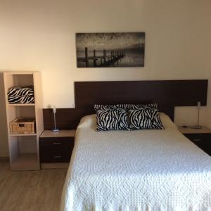 罗列特海岸Apartamentos SOL Center Lloret的一间卧室配有一张带黑白色棉被的床
