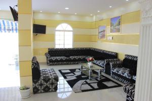 苏尔鲁录亚特阿尔菲亚公寓式酒店的客厅配有黑色沙发和桌子