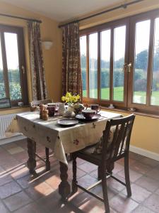 里弗姆Wood Farm Kerdiston的一间带桌椅和窗户的用餐室