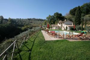 蒙特法尔科Casa Vacanze Vecciano的一个带椅子的游泳池和一个背景房子