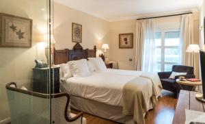 圣比森特德拉松谢拉卡索纳德尔博蒂卡里奥酒店的一间酒店客房,配有一张床和一个玻璃门
