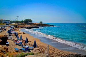 古瓦伊Sea View Beachfront Villa Maria的海滩上设有椅子和遮阳伞,还有大海
