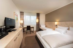 比勒费尔德比尔费尔德约翰尼斯堡美居酒店的配有一张床和一台平面电视的酒店客房