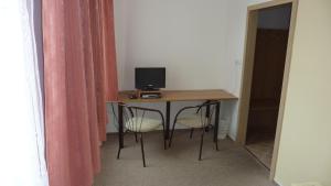 波利奇卡THT酒店的一间配备有一张书桌的房间,电脑在里面