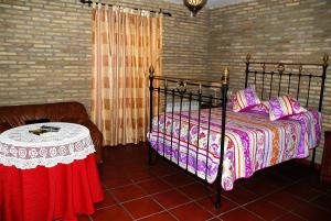El Real de la JaraHostal la Encina的一间卧室配有一张床和一张桌子