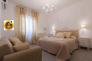 蒙德罗Holiday & House - Imparato Vacanze Prestige Mondello的一间卧室配有一张床、一把椅子和一个吊灯。
