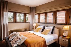 波佩林赫Charmehotel Manoir Ogygia的一间卧室配有一张带窗户的大床