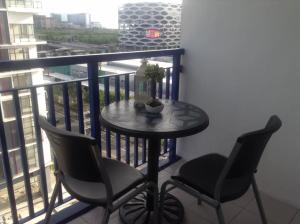 马尼拉马尼拉亚洲购物中心海洋公寓式酒店的阳台配有一张小桌子和两把椅子