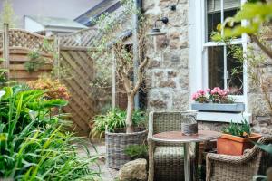 圣艾夫斯Headland House Luxury B&B的庭院配有桌椅和植物