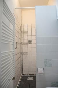 海牙约克斯特公寓的浴室设有白色瓷砖淋浴。