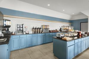 堪萨斯城乡村旅馆&西村堪萨斯市套房的一间设有蓝色橱柜和柜台的大厨房