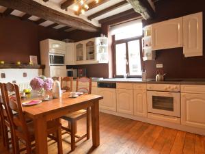 特文Spacious holiday home in Teuven with garden的厨房铺有木地板,配有木桌。